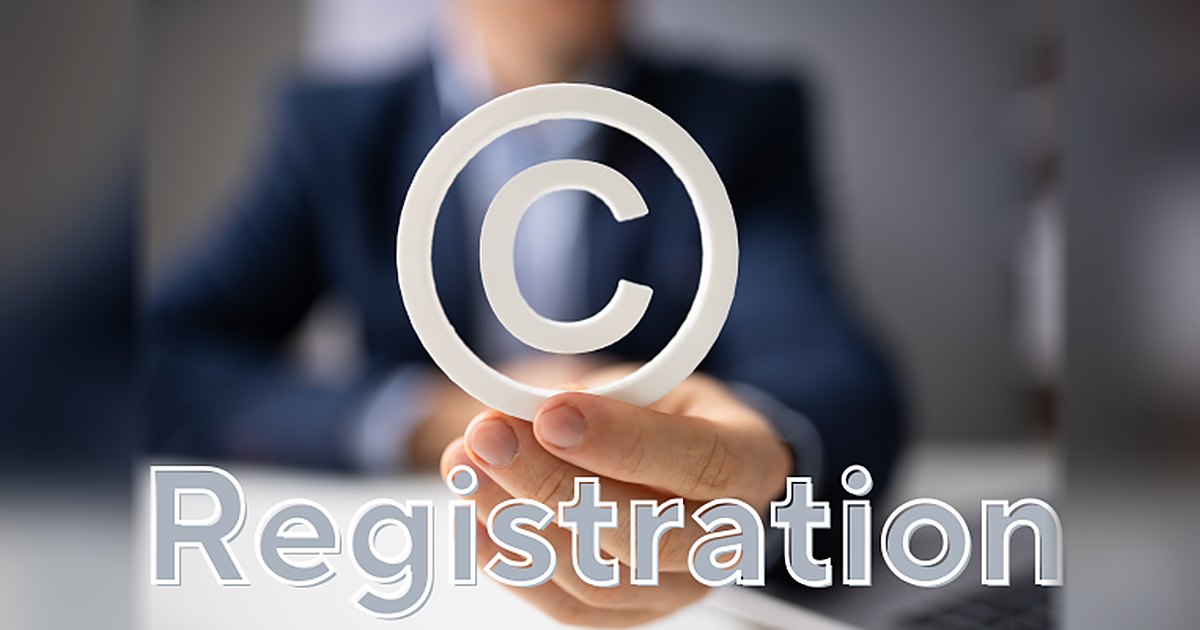 Hand holding a copyright symbol above the word Registration